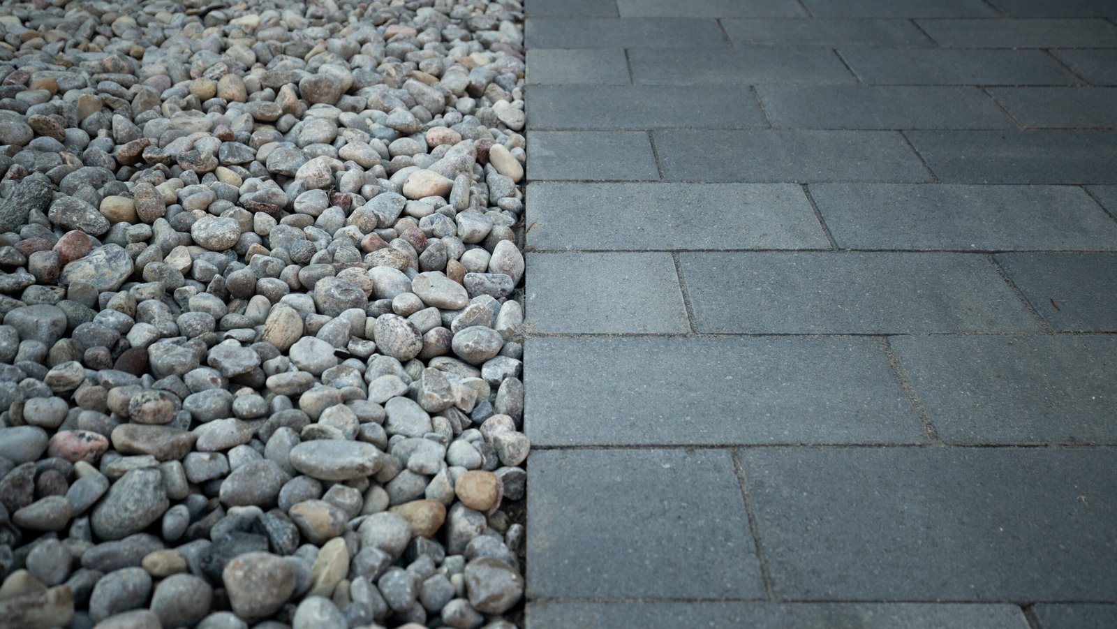 Luxury residential backyard featuring a mix of modern interlock and natural stone borders by UBL Group.